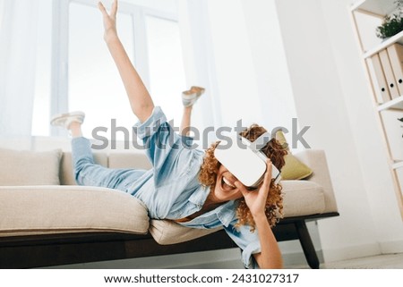 Futuristic Joy: A Young Woman Smiling with Excitement while Using Virtual Reality Glasses in her Modern Living Room