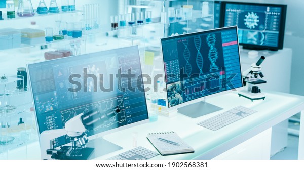 Futuristic laboratory equipment - coronavirus\
testing. Computer screens in laboratory. DNA models and coronavirus\
research