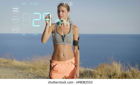 A futuristic portrait of a sportswoman, uses a digital hologram rhythm of speed and movement in the phone, the background of the sea. Concept: future technologies, love sports, jogging, sportswear. - Powered by Shutterstock