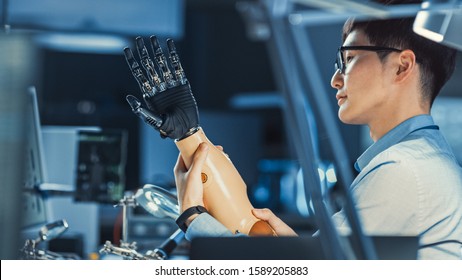 Futuristic Prosthetic Robot Arm Being Tested By A Professional Japanese Development Engineer In A High Tech Research Laboratory With Modern Computer Equipment.