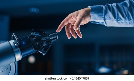 Futuristic Robot Arm Touches Human Hand In Humanity And Artificial Intelligence Unifying Gesture. Conscious Technology Meets Humanity. Concept Inspired By Michelangelo's Creation Of Adam