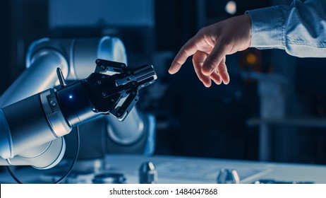Futuristic Robot Arm Touches Human Hand in Humanity and Artificial Intelligence Unifying Gesture. Conscious Technology Meets Humanity. Concept Inspired by Michelangelo's Creation of Adam - Shutterstock ID 1484047868
