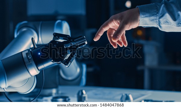 Futuristic Robot Arm Touches Human Hand in Humanity\
and Artificial Intelligence Unifying Gesture. Conscious Technology\
Meets Humanity. Concept Inspired by Michelangelo\'s Creation of\
Adam