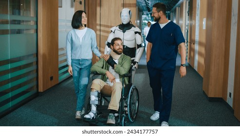 Futuristic robot with artificial intelligence helping injured young patient in wheelchair in modern hospital. Qualified male doctor and young female nurse walking with robot and patient in corridor.