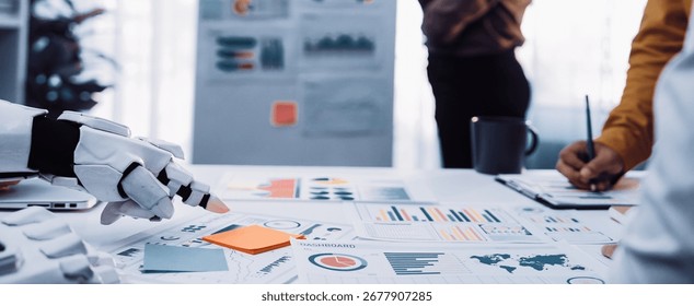 A futuristic robot hand interacts with data and charts in a modern business meeting, showcasing collaboration and innovation among professionals discussing strategic growth.Noogenesis