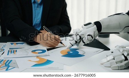 A futuristic setting where a robot collaborates with a human, showcasing charts and graphs. This image represents the blending of technology with human creativity in the workplace.Noogenesis