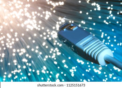 Futuristic technological background, closeup on the end of optical fiber network cable on blue background