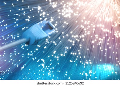 Futuristic technological background, closeup on the end of optical fiber network cable on blue background