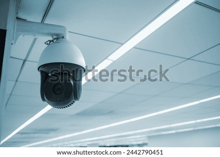 Futuristic technology CCTV Security camera surveillance video recording device, closed circuit television watching over civilians. Security equipment in an airport, copyspace background.