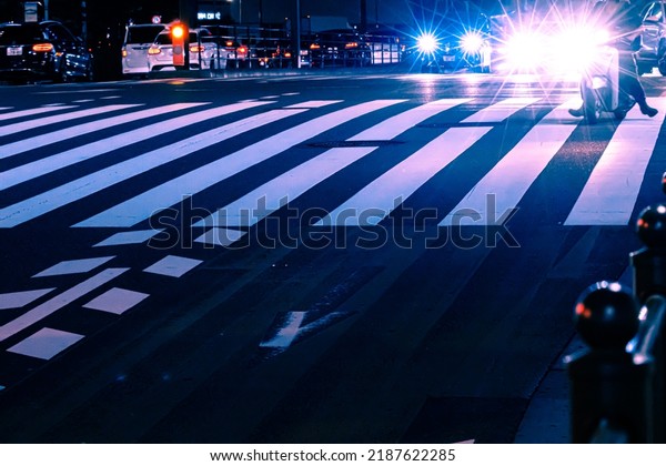 Futuristic transportation in smart\
city concept. Abstract of headlight of cars and vehicle stopping at\
zebra crossing in urban area during evening congestion rush\
hour.