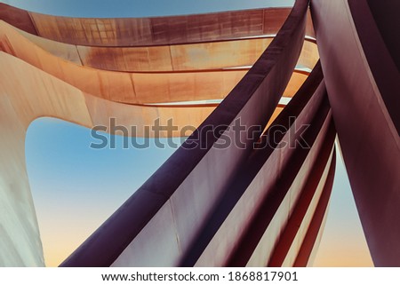 Futuristic urban architecture. Art arch vertical triangles made of brown tin metal with a blue sky background. Abstract backdrop. Selective focus. Copy space