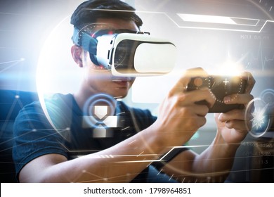 Futuristic virtual reality VR headset technology playing video games using mobile phone device shooting user interface, Asian man sitting on sofa free time enjoinment having fun at home living room - Shutterstock ID 1798964851