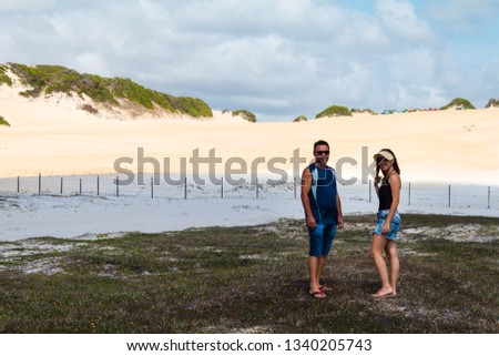 Gabi and Natal (family) posing for photos in Natal with Genipabu Dunes at background.