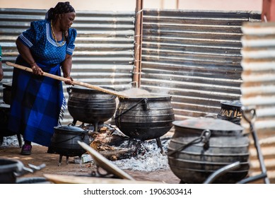Gaborone, Botswana - November 03 2018: An Old African Women Wearing Botswana African Attire Cooking In Open Fire At A Wedding
