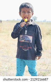 Gadag, Karnataka, India - February 22, 2022: A Village Young Kid Or Boy Eating A Popsicle(Called As Kulfi In India).