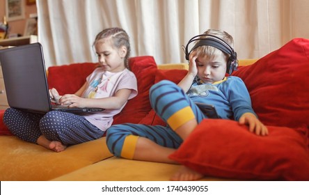 Gadget dependence, digital native generation alpha, cute kid lying on sofa and using gadgets from the early morning at home, online education and entertainment