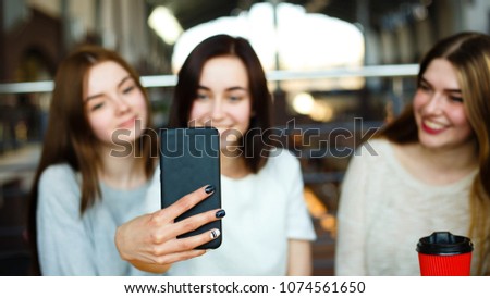 Gadget and social networking addiction, friendship, conversation concept. Woman holding smartphone on background of her friends