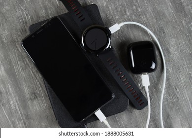 Gadgets Are Charged On The Table - Phone, Smart Watch, Headphones, Tablet
