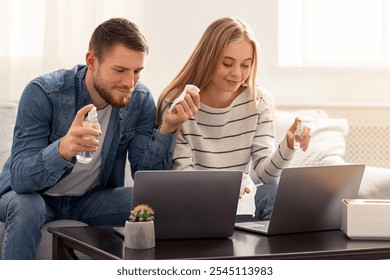 Gadgets disinfection. Young man and woman cleaning laptops with sanitizers after work at home, panorama, free space - Powered by Shutterstock