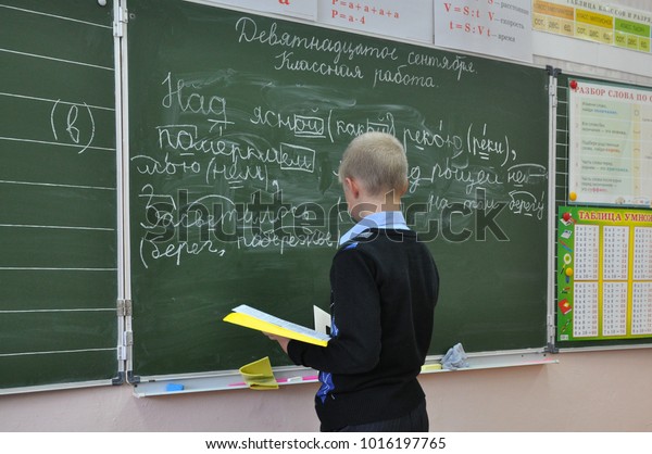Gadjievo, Russia - September 19, 2012: The pupil\
performs the task at the school board at the lesson of the Russian\
language