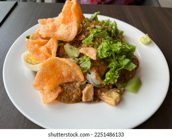 Gado gado is an Indonesian salad of raw slightly boiled, blanched or steamed vegetables and hard boiled eggs, fried tofu and tempeh. - Shutterstock ID 2251486133