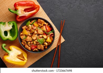 Gai Pad Med Mamuang Or Thai Cashew Chicken In Black Bowl On Dark Slate Backdrop. Kai Med Ma Muang Is Thai Cuisine Dish With Chicken Meat, Capsicum, Onion, Scallions, Chilli. Thai Food. Copy Space