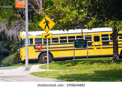 Gainesville, USA - April 27, 2018: Road Street School Bus In Downtown Florida City With University Of Florida UF Campus Sign For Simpson Hall