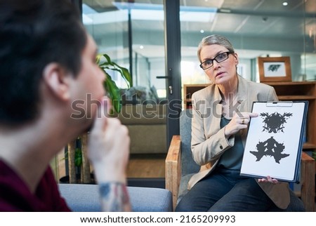 Gaining access into the subconscious mind. Shot of a mature psychologist conducting an inkblot test with her patient during a therapeutic session.