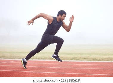 Gaining some serious speed. Full length shot of a handsome young male athlete running on an outdoor track.