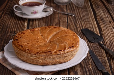 Galette des rois for the Epiphany on a wooden table - Shutterstock ID 2232252667