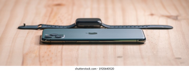 Galle, Sri Lanka - 02 19 2021: Apple IPhone 11 Pro Max And Apple Watch Series 6 Lay Flat On A Wooden Table With A Low Angle Side View, Luxury, And Lifestyle Concept.
