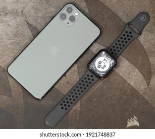 Galle, Sri Lanka - 02 19 2021: Apple IPhone 11 Pro Max And Apple Watch Series 6 Lay Flat Parallel To Each On A Wooden Table, Luxury, And Lifestyle Concept. Overhead View Photograph.