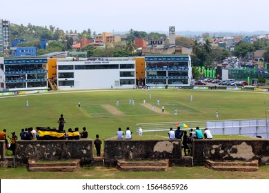 Galle / Sri Lanka - March, 15, 2019 – Fans Watching A Cricket Match Happening At Galle International Stadium. They Are Sitting In The Walls Of The Old Walled Town Of Galle, A Former Colonial City That