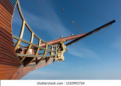 Galleon Sailing Ship Bow With Angel Figurehead Against Blue Sky.