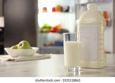 Gallon and glass of milk on table in kitchen, space for text - Shutterstock ID 1925118863