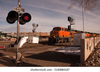 GALLUP, NEW MEXICO - DECEMBER 18, 2013: A BNSF train headed by locomotive #7114 crosses the railroad crossing at Second St, along Route 66 in downtown.