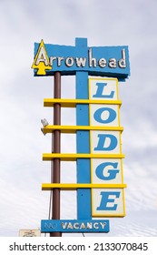 Gallup, New Mexico, USA, February 10, 2019 - Exterior low angle daytime view of vintage yellow and blue Arrowhead Lodge sign located along Route 66