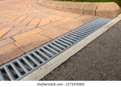 Galvanised steel drainage channel in a red block paved residential driveway - Shutterstock ID 2171476005