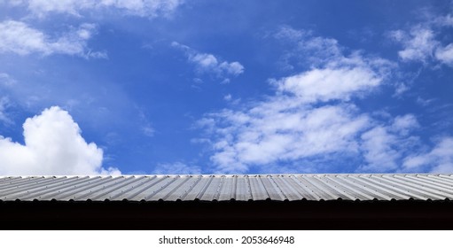 Galvanized surface, steel roofing sheet, house and sky view with bright white clouds in sunny day