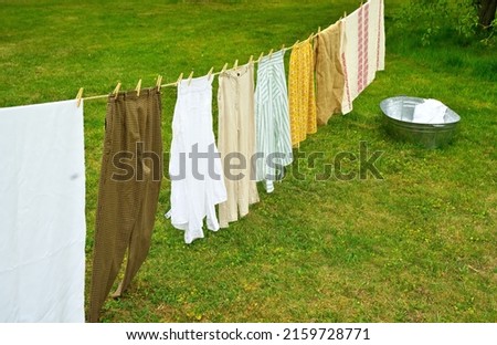 A galvanized trough and washed things are dried on a rope. Selective focus.