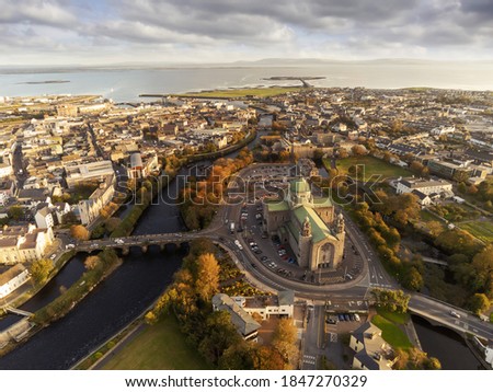 Galway Cathedral building at sunset. Aerial drone view, Warm light, Galway town, Ireland, Popular landmark. Cloudy sky.