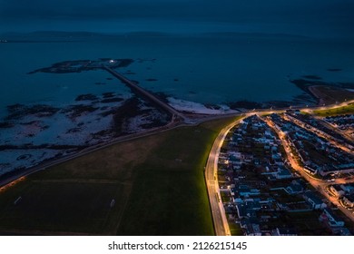 Galway city illuminated at night, South park and Mutton island and Claddagh area. Aerial high point view. Town at night. Popular travel destination. City lights glow in the dark.