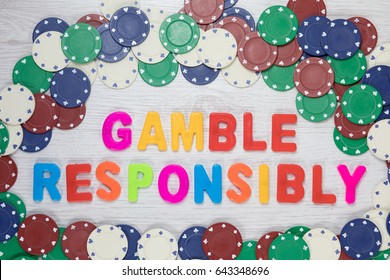 Gamble Responsibly and know when to quit in a conceptual image with assorted denominations of casino chips forming a frame around colorful text viewed from above - Shutterstock ID 643348696