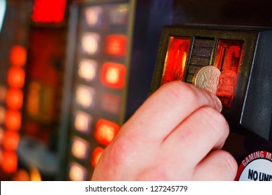 Gambler Inserts Pound Coin Into Gambling Machine At Casino