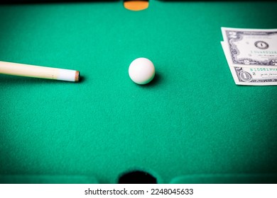 Gambling ardor game.Dollar cash and white billiard ball.Dollar paper banknotes on the game table.Selective focus. - Shutterstock ID 2248045633