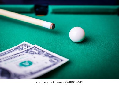 Gambling ardor game.Dollar cash and white billiard ball.Dollar paper banknotes on the game table.Selective focus. - Shutterstock ID 2248045641
