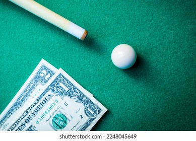 Gambling ardor game.Dollar cash and white billiard ball.Dollar paper banknotes on the game table.Selective focus. - Shutterstock ID 2248045649