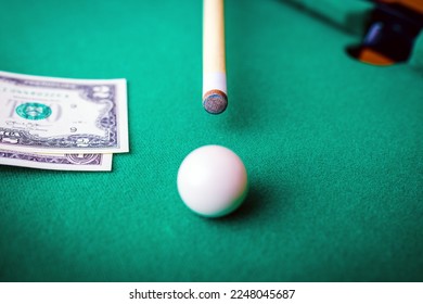 Gambling ardor game.Dollar cash and white billiard ball.Dollar paper banknotes on the game table.Selective focus. - Shutterstock ID 2248045687