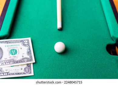 Gambling ardor game.Dollar cash and white billiard ball.Dollar paper banknotes on the game table.Selective focus. - Shutterstock ID 2248045715