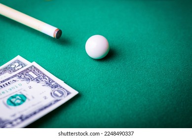 Gambling ardor game.Dollar cash and white billiard ball.Dollar paper banknotes on the game table.Selective focus. - Shutterstock ID 2248490337